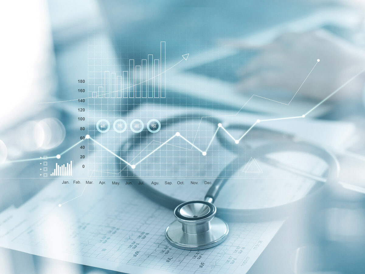 A stethoscope on financial documents overlaid with healthcare data charts and graphs